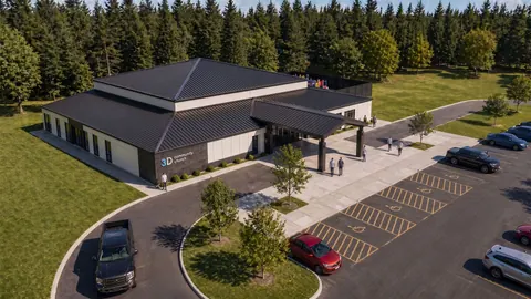 Aerial architectural rendering of 3D Community Church in Sanford, NC, showing the hip-roofed building, covered entry, curved drop-off drive and parking layout, site planning by Ossa Studio.